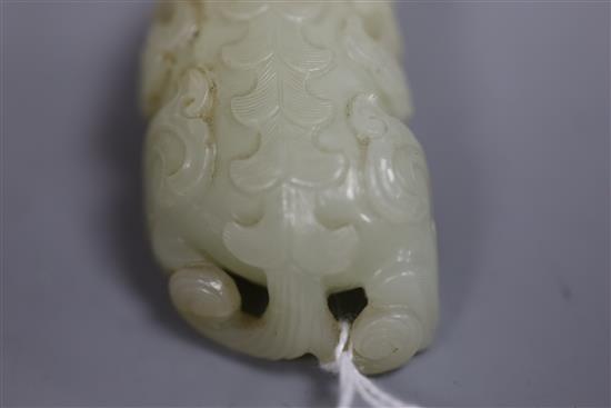 A Chinese pale celadon jade figure of lion-dog, bixi, 17th century, L. 6.8cm, wood stand